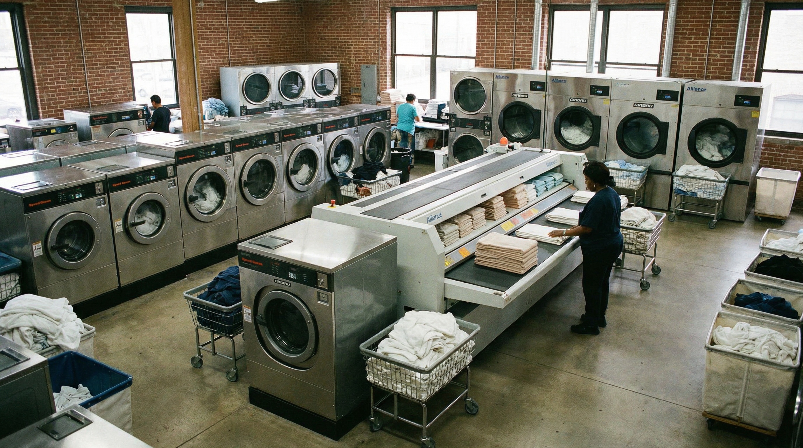 Various types of commercial laundry equipment including washers, dryers, and folders in layout