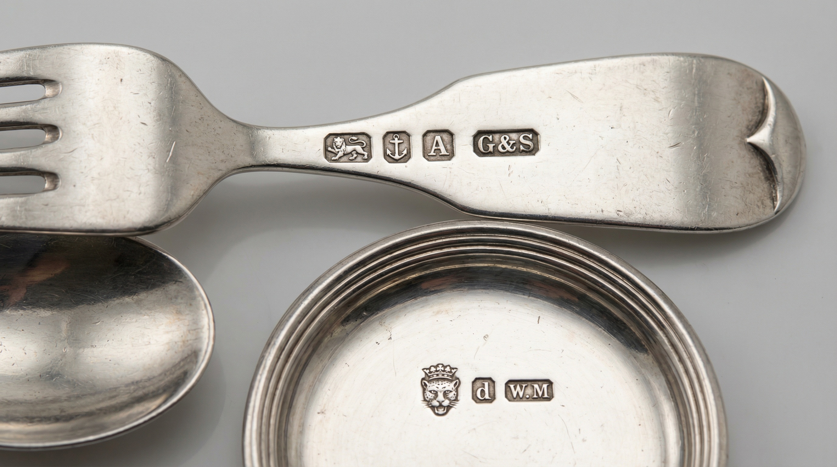 Close up of silver hallmarks and makers marks on various pieces