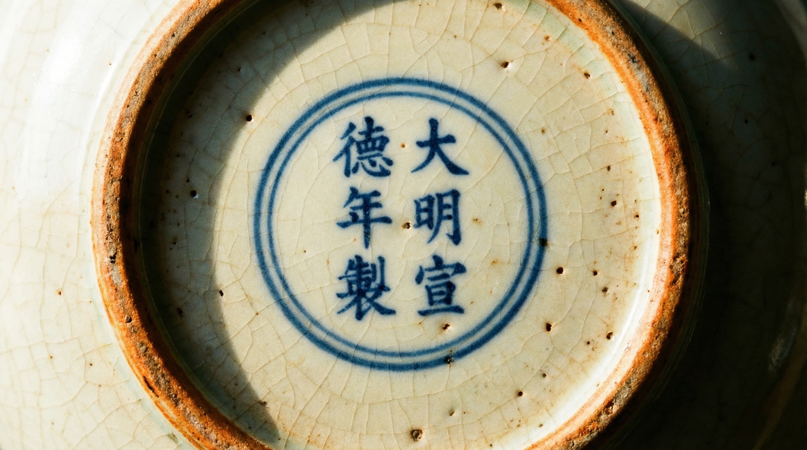 Close-up of Chinese porcelain showing dynasty marks and traditional glazing