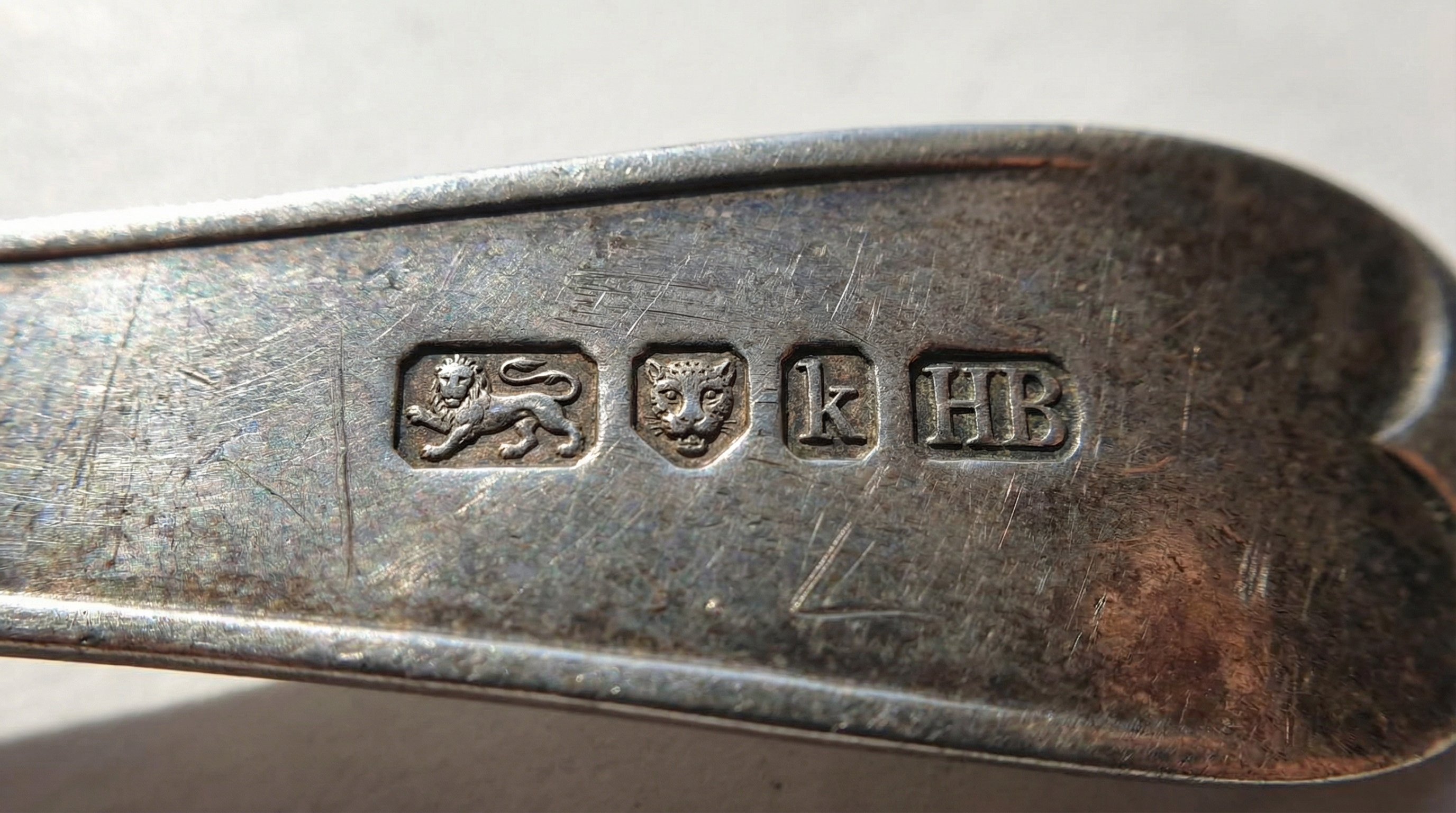 close-up of hallmarks and maker marks on antique silver piece